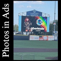 a baseball field with a large screen advertising photos in ad